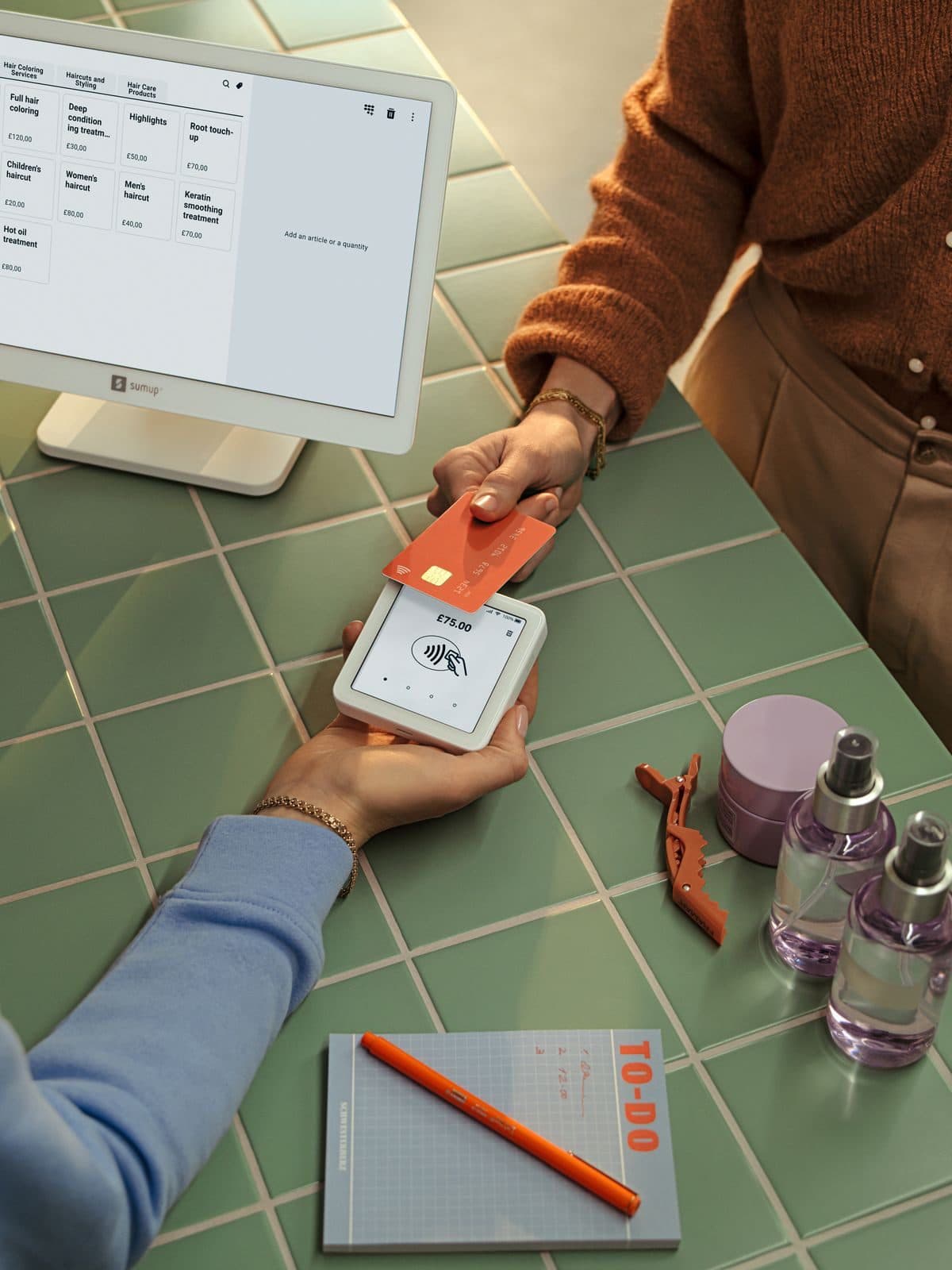 A salon customer paying by card at the point of sale